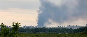 Nach dem Beschuss durch russische Truppen steigt eine Rauchsäule hinter Wohnhäusern auf. 