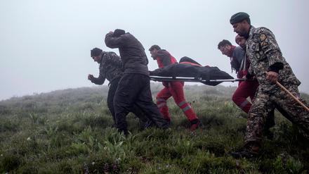 Rettungskräfte bergen die sterblichen Überreste einer Person, die bei dem Absturz ums Leben kam.