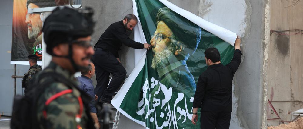 Ein Plakat zum Gedenken an Raisi wird augehängt.