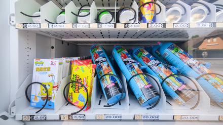 Ein Warenautomat, unter anderem mit Lachgasflaschen bestückt, steht vor einem Ladengeschäft.