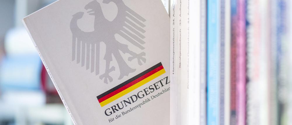 Ein Grundgesetz steckt in einem Bücherregal (Symbolfoto).