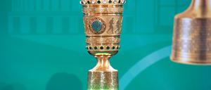 Der DFB-Pokal steht vor einer türkisen Leinwand.