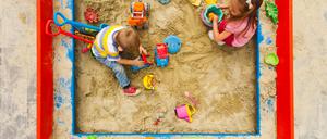 Kinder spielen in einem Sandkasten.