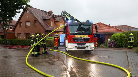 22.05.2024, Schleswig-Holstein, Hamberge: Einsatzkräfte sind mit Nachlöscharbeiten an einem Wohnhaus im Kreis Stormarn beschäftigt, das nach Angaben der Feuerwehr bei Unwetter durch einen Blitzschlag in Brand geraten war. 