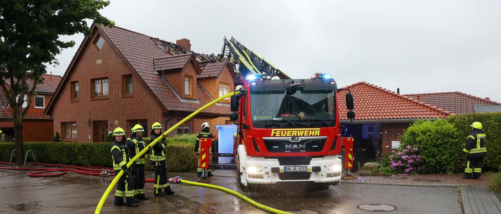 22.05.2024, Schleswig-Holstein, Hamberge: Einsatzkräfte sind mit Nachlöscharbeiten an einem Wohnhaus im Kreis Stormarn beschäftigt, das nach Angaben der Feuerwehr bei Unwetter durch einen Blitzschlag in Brand geraten war.