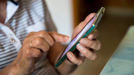 Eine Frau bedient ein Mobiltelefon. (Symbolbild)