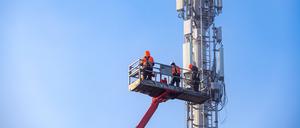 Arbeiter stellen einen 5G-Mobilfunkmast in Frankreich auf. 