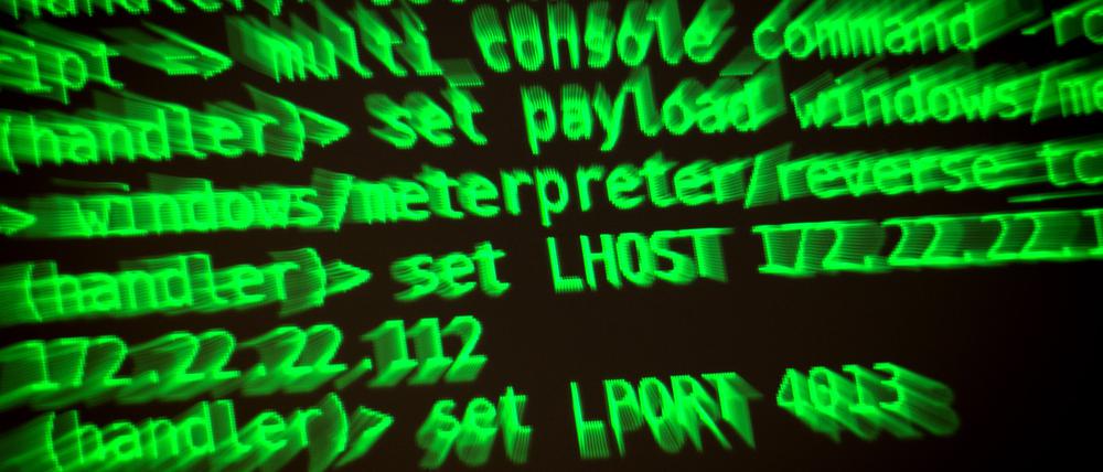 Buchstaben und Zahlen leuchten auf einem Bildschirm, auf dem ein Hacker-Programm geöffnet ist.