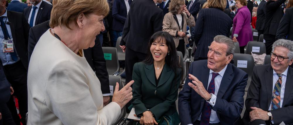 Entspannte Begrüßung: die ehemaligen Kanzler Angela Merkel und Gerhard Schröder beim Staatsakt zu „75 Jahre Grundgesetz“ auf dem Forum zwischen Bundestag und Bundeskanzleramt.