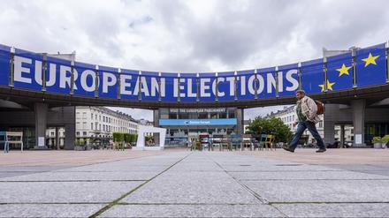 dpatopbilder - 23.05.2024, Belgien, Brüssel: Ein Mann geht vor dem Europäischen Parlament vor einer Debatte mit den Spitzenkandidaten für die Wahlen zum Europäischen Parlament. Die Spitzenkandidatinnen und -kandidaten der großen europäischen Parteienfamilien für das Amt der Kommissionspräsidentin bzw. des Kommissionspräsidenten debattieren über ihre Visionen für Europa und die aktuellen politischen Herausforderungen der EU. Foto: Geert Vanden Wijngaert/AP/dpa +++ dpa-Bildfunk +++