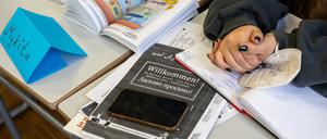 Ein Mädchen aus der Ukraine sitzt mit ihrem Unterrichtsmaterial in einer Klasse. 