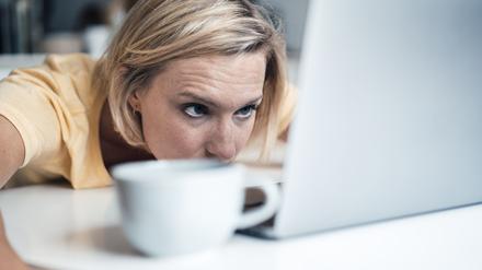 Müde Arbeitnehmerin hängt vor ihrem Laptop.