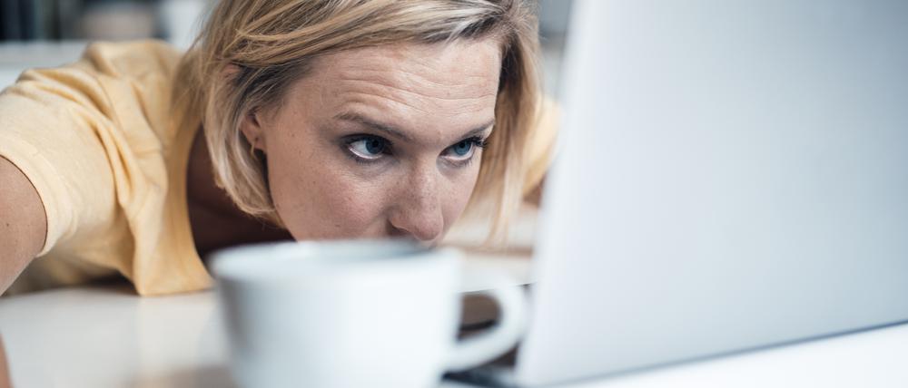 Müde Arbeitnehmerin hängt vor ihrem Laptop.