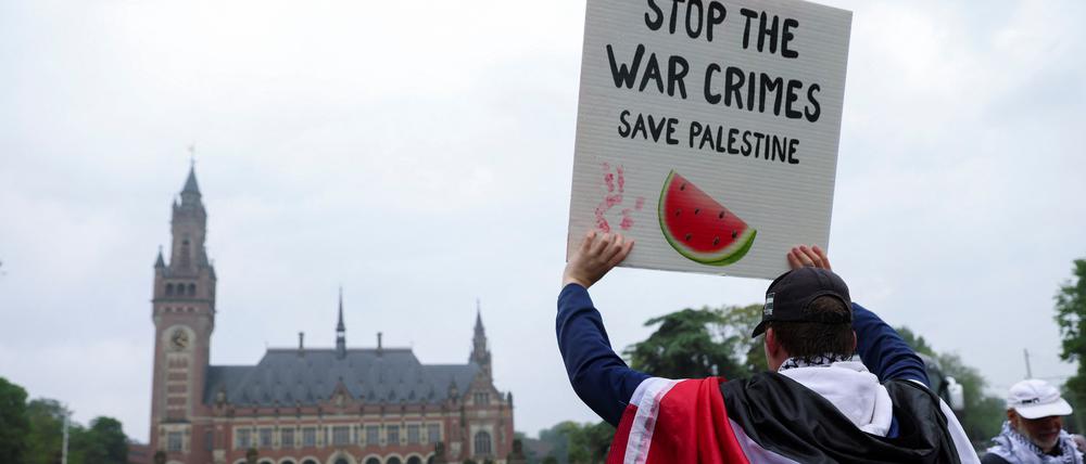 Ein Demonstrant hält ein Plakat hoch vor dem Internationalen Gerichtshof in Den Haag.