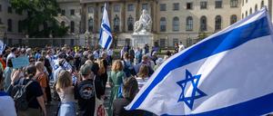 Teilnehmer stehen mit israelischen Fahnen bei einer Kundgebung von Fridays for Israel vor der Humboldt-Universität.
