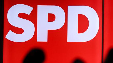 Mikrofone stehen vor einer leuchteten Wand mit dem Logo der SPD.