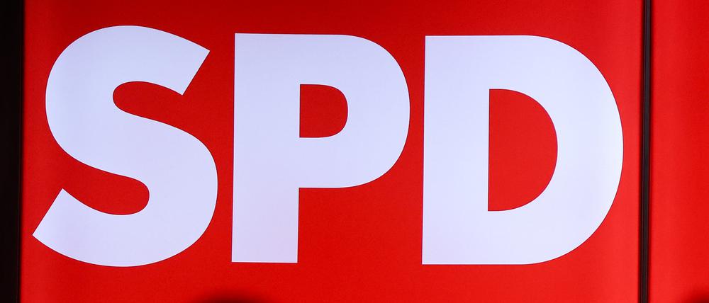 Mikrofone stehen vor einer leuchteten Wand mit dem Logo der SPD.