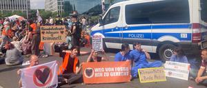 Aktivisten der Letzten Generation blockieren die Zufahrt vom Demokratiefest.