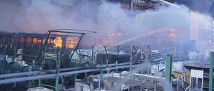 Feuerwehrleute löschen ein Feuer, nachdem zwei gelenkte Bomben einen großen Baumarkt getroffen haben. 