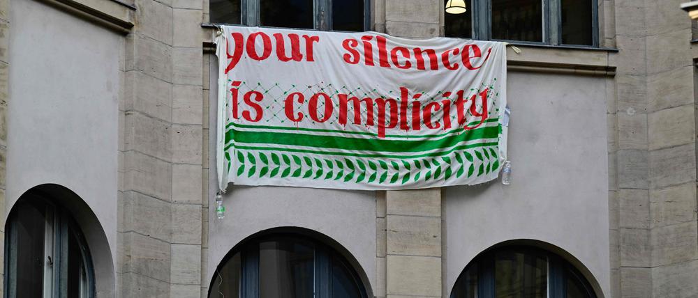 Ein Banner mit der Aufschrift „Your silence is complicity“ hängt am besetzten Institut für Sozialwissenschaften der Humboldt-Universität.