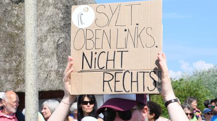 „Sylt oben links nicht rechts“ steht auf einem Plakat, dass eine Frau bei einer Mahnwache am Sonntag auf Sylt in der Hand hält. Im Strönwai in Kampen, wo sich auch der Pony-Club befindet, hatten sich laut Polizei rund 80 Menschen anlässlich des um Rassismus-Eklats um ein Partyvideo auf Sylt versammelt und wollen ein Zeichen gegen Rassismus setzen.  