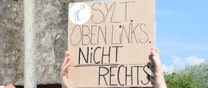 „Sylt oben links nicht rechts“ steht auf einem Plakat, dass eine Frau bei einer Mahnwache am Sonntag auf Sylt in der Hand hält. Im Strönwai in Kampen, wo sich auch der Pony-Club befindet, hatten sich laut Polizei rund 80 Menschen anlässlich des um Rassismus-Eklats um ein Partyvideo auf Sylt versammelt und wollen ein Zeichen gegen Rassismus setzen.  