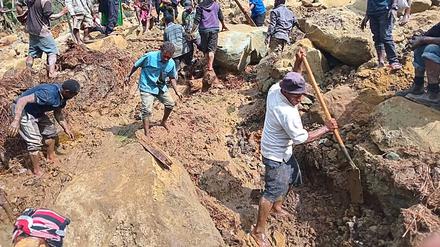 Menschen, die nach einem Erdrutsch im Dorf Yambali in der Region Maip Mulitaka in der Provinz Enga in Papua-Neuguinea graben.