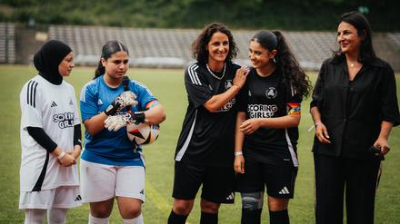 Tuğba Tekkal (Mitte) und ihre Schwester Düzen Tekkal (rechts) mit den Spielerinnen der Scoring Girls. 