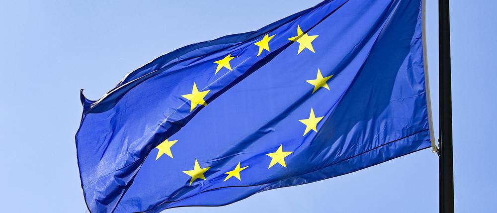 Eine Europaflagge weht vor blauem Himmel.