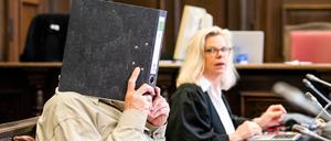 Ein angeklagter mutmaßlicher «Reichsbürger» sitzt im Hanseatischen Oberlandesgericht neben seiner Rechtsanwältin Ina Franck-Holst im Saal.