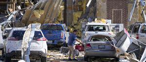Ein Mann betrachtet ein beschädigtes Auto, nachdem ein Tornado gewütet hat. Heftige Stürme haben im Süden der USA große Schäden angerichtet und mehreren Menschen das Leben gekostet. 
