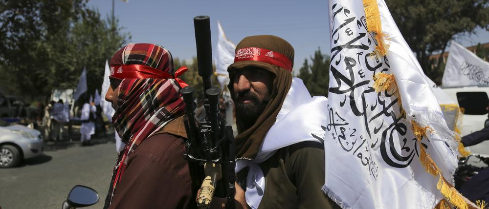 Taliban schwenken Fahnen.