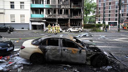 Feuerwehrleute stehen vor einem Wohnhaus, in dem ein Brand wütete (Archivbild).