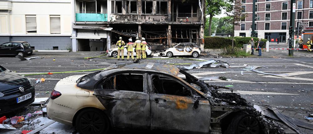 Feuerwehrleute stehen vor einem Wohnhaus, in dem ein Brand wütete (Archivbild).