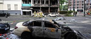 Feuerwehrleute stehen vor einem Wohnhaus, in dem ein Brand wütete (Archivbild).
