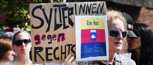 „SylterInnen gegen Rechts“ steht auf einem Schild, das eine Frau bei einer Mahnwache in der Hand hält.