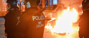 Polizeibeamte stehen auf der Sonnenallee in Neukölln an zwei in Brand gesetzten Mülltonnen. In der Sonnenallee kam es zu teilweise gewalttätigen Auseinandersetzungen von Menschen, die «Freiheit für Palästina» skandierten.