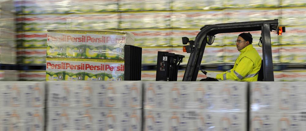 Ein Henkel-Mitarbeiter bewegt Paletten mit Persil-Kartons.