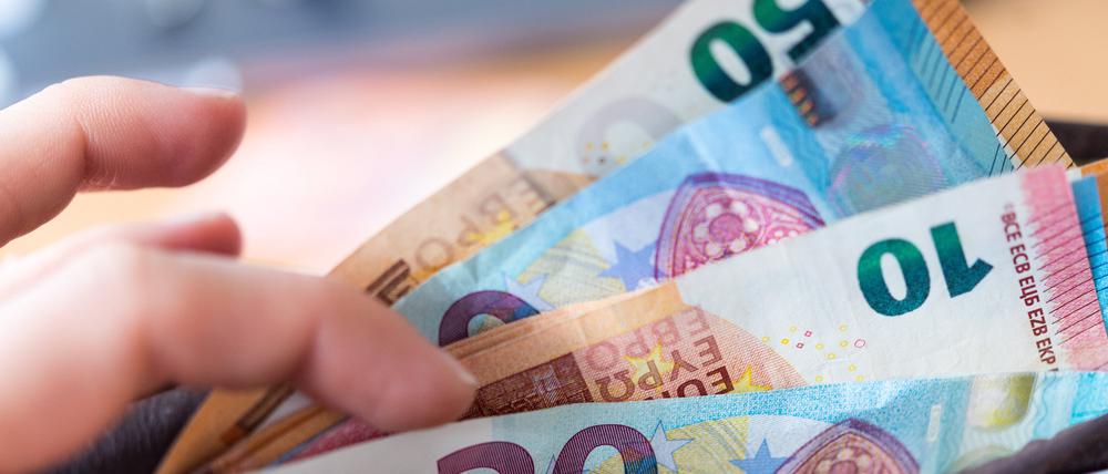 ARCHIV - 04.12.2018, Sachsen, Dresden: Eine Frau hält eine Geldbörse mit Banknoten in der Hand. (zu dpa: «Verbraucherpreise in Sachsen-Anhalt gestiegen») Foto: Monika Skolimowska/dpa-Zentralbild/dpa +++ dpa-Bildfunk +++