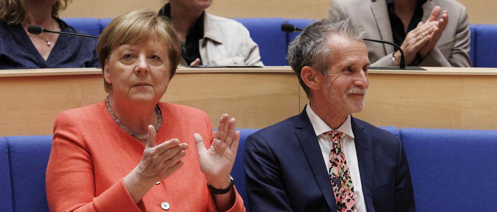 Angela Merkel (CDU), Bundeskanzlerin a.D, sitzt neben Schauspieler Ulrich Matthes (r), der heute geehrt wird. Die Konrad-Adenauer-Stiftung ehrt den Schauspieler für Verdienste als herausragende Persönlichkeit der deutschsprachigen Kultur.