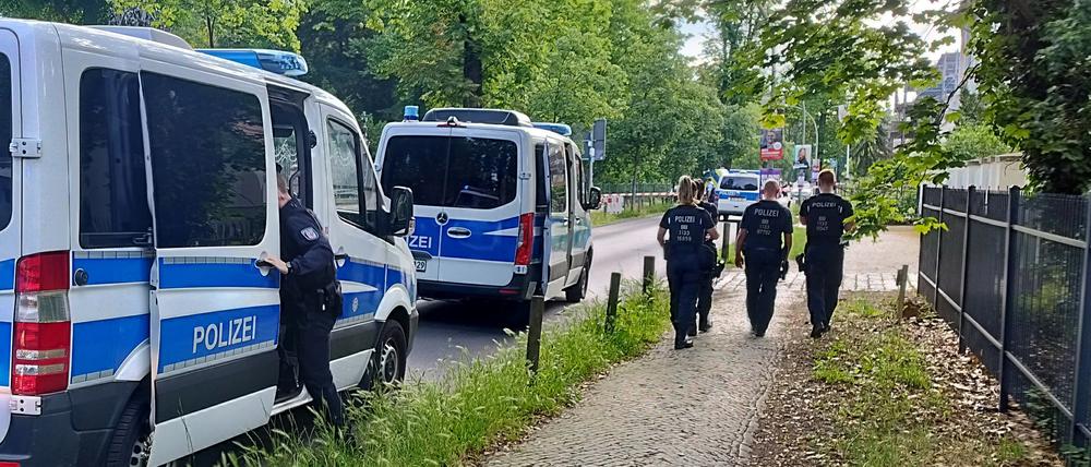Polizisten gehen am abgesperrten Tatort in der Potsdamer Geschwister-Scholl-Straße entlang. Ein Wachmann in einer Gemeinschaftsunterkunft für Geflüchtete ist schwer verletzt worden.