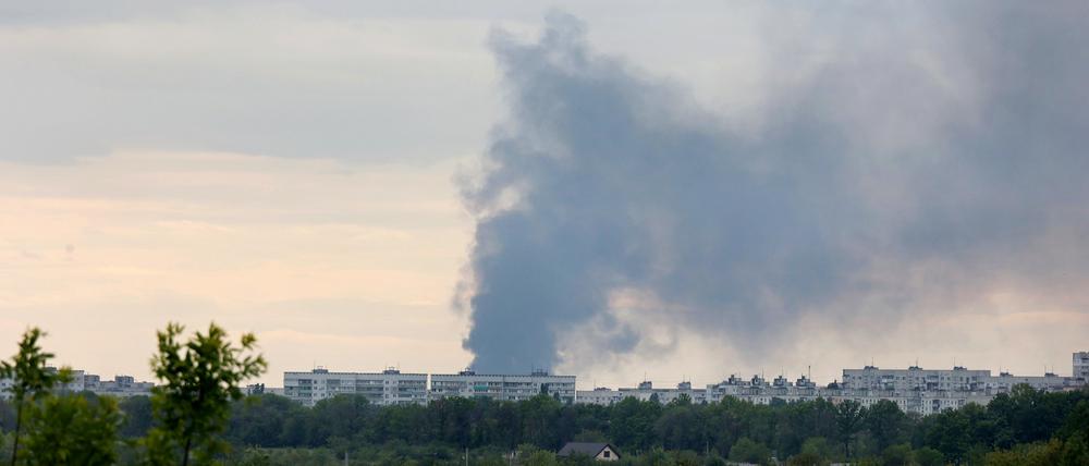 Nach dem Beschuss durch russische Truppen steigt eine Rauchsäule hinter Wohnhäusern auf.