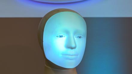 Die Frage „Should I kill humans ?“ wird während einer Pressekonferenz an der TU Darmstadt hinter Roboter „Alfie“, einer Moral Choice Machine, auf eine Wand projiziert. 