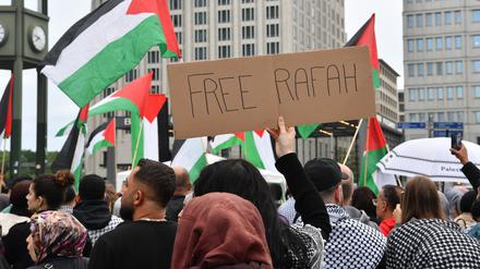 30.05.2024, Berlin: Teilnehmer einer propalästinensischen Demonstration zeigen palästinensische Flaggen und ein Schild mit der Aufschrift "Free Rafah" am Potsdamer Platz. Foto: Paul Zinken/dpa +++ dpa-Bildfunk +++