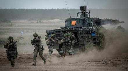 Soldaten der Bundeswehr springen zum Abschluss bei der Nato-Übung Quadriga 2024 aus einem Puma-Schützenpanzer.