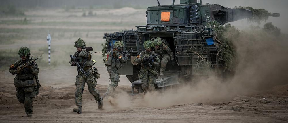 Soldaten der Bundeswehr springen zum Abschluss bei der Nato-Übung Quadriga 2024 aus einem Puma-Schützenpanzer.