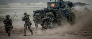 Soldaten der Bundeswehr springen zum Abschluss bei der Nato-Übung Quadriga 2024 aus einem Puma-Schützenpanzer.