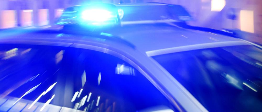 Ein Streifenwagen der Polizei steht mit eingeschaltetem Blaulicht auf der Straße. (Symbolbild)