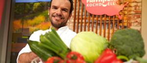 Steffen Henssler, fernseherfahrener Koch, steht in der Studiokulisse der Sendung „Familien-Kochduell“.