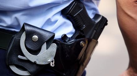 Ein Polizist mit Handschellen und Pistole am Gürtel. 